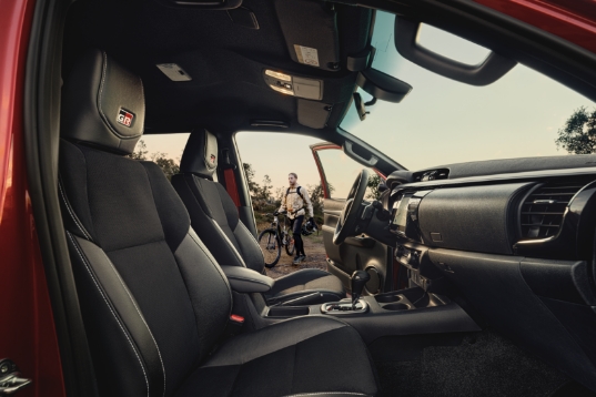Widok na wnętrze Toyoty i rowerzystę stojącego za samochodem